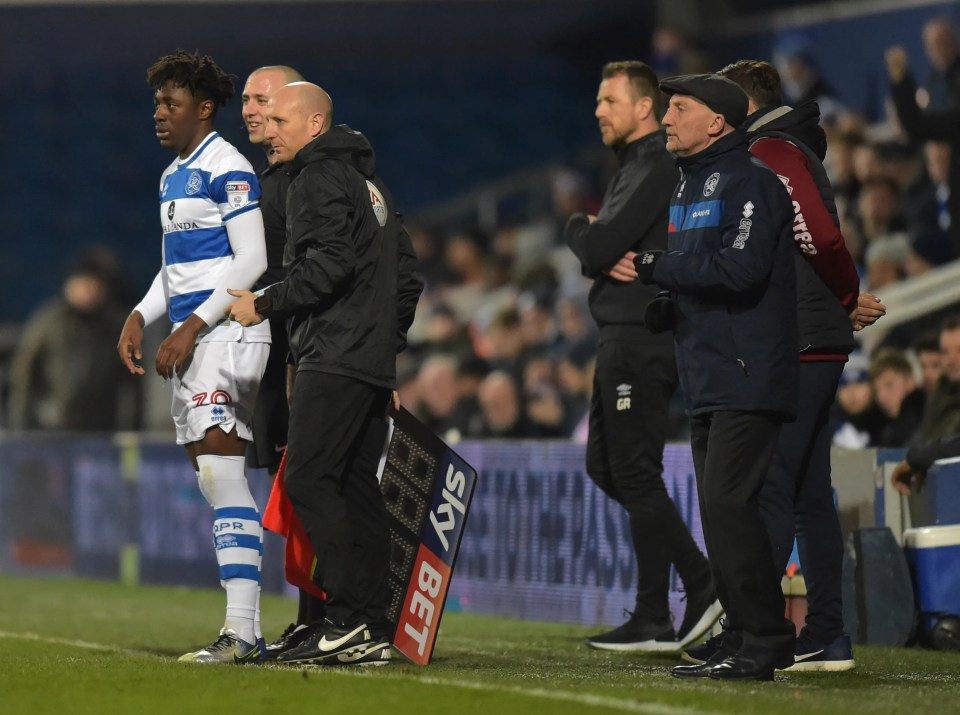 Soccer managers and a player on the sidelines.