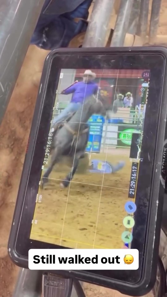 Tablet screen showing a rodeo contestant falling off a horse.