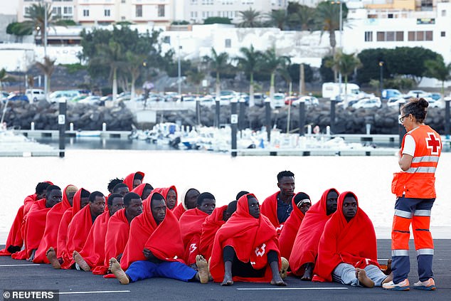 Migrants (pictured) rest after disembarking from a Spanish coast guard vessel on April 13, 2025