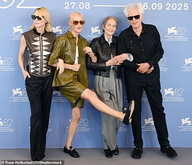 She playfully kicked one of her long legs up into the air as she linked arms with her co-stars for a group shot with director Jim