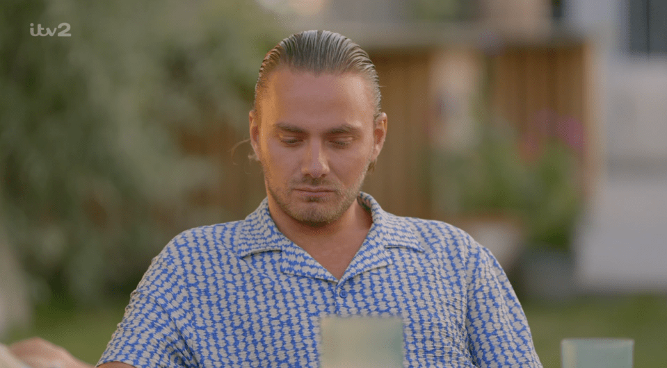 Man looking down in a patterned shirt.