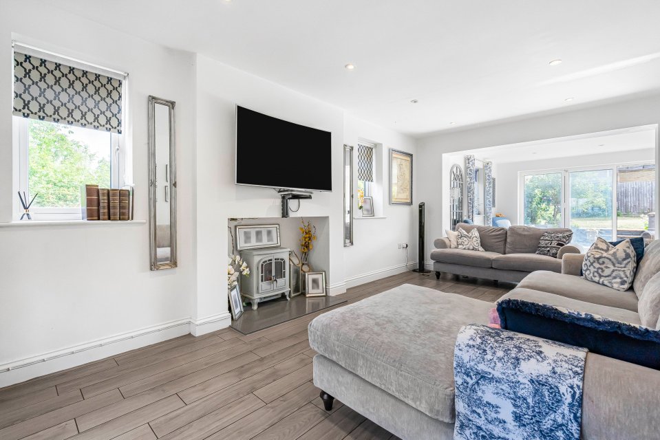 Living room with gray sectional sofa, fireplace, and flat-screen TV.