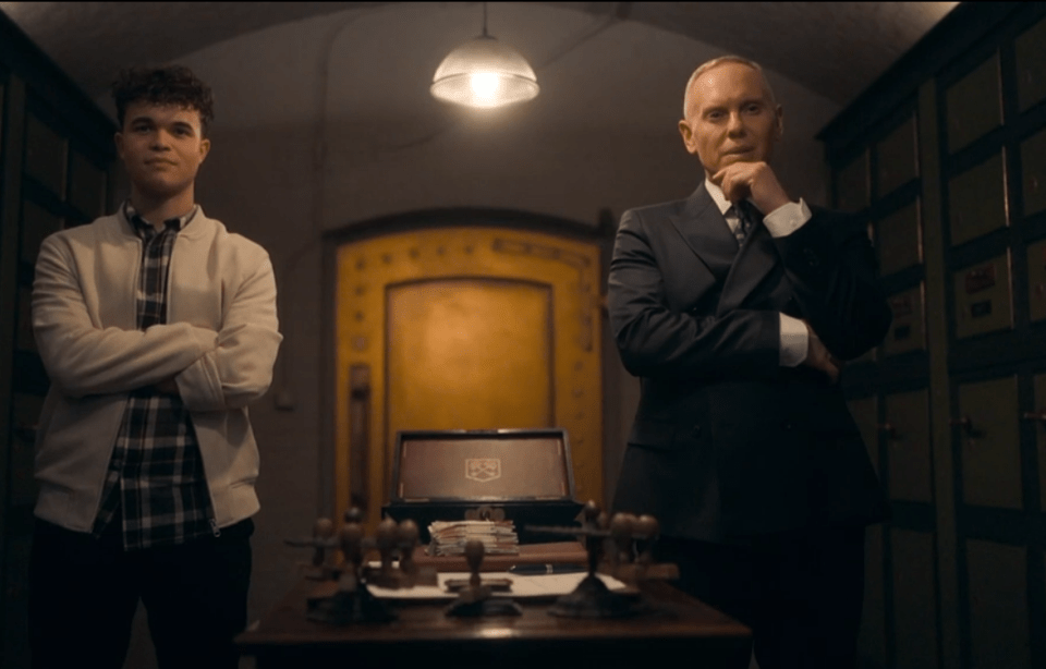 Two men standing in a vault-like room.