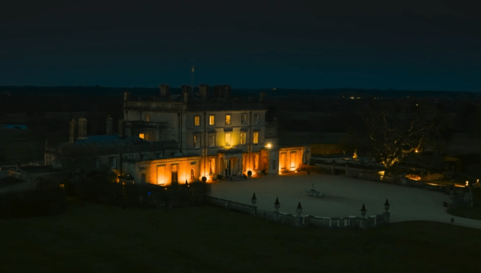 Large mansion at night, illuminated.