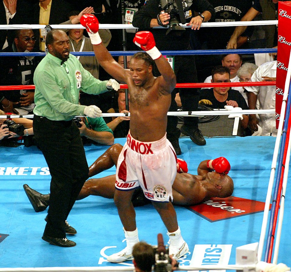 Lennox Lewis celebrating victory over Mike Tyson in a boxing match.
