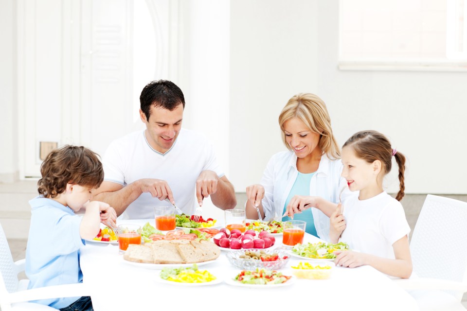 Family eating outdoors at a table.