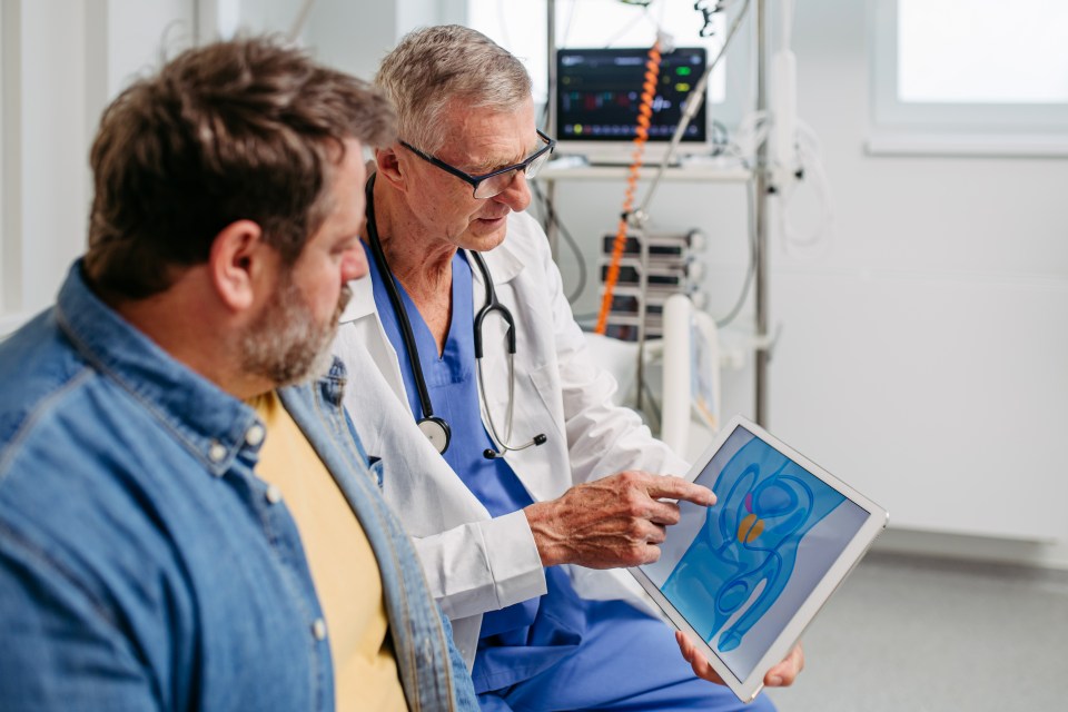 Doctor explaining prostate examination to a patient using a tablet.