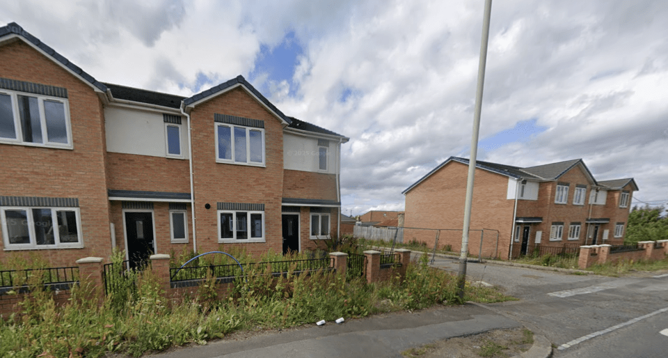 Empty housing estate with overgrown weeds.