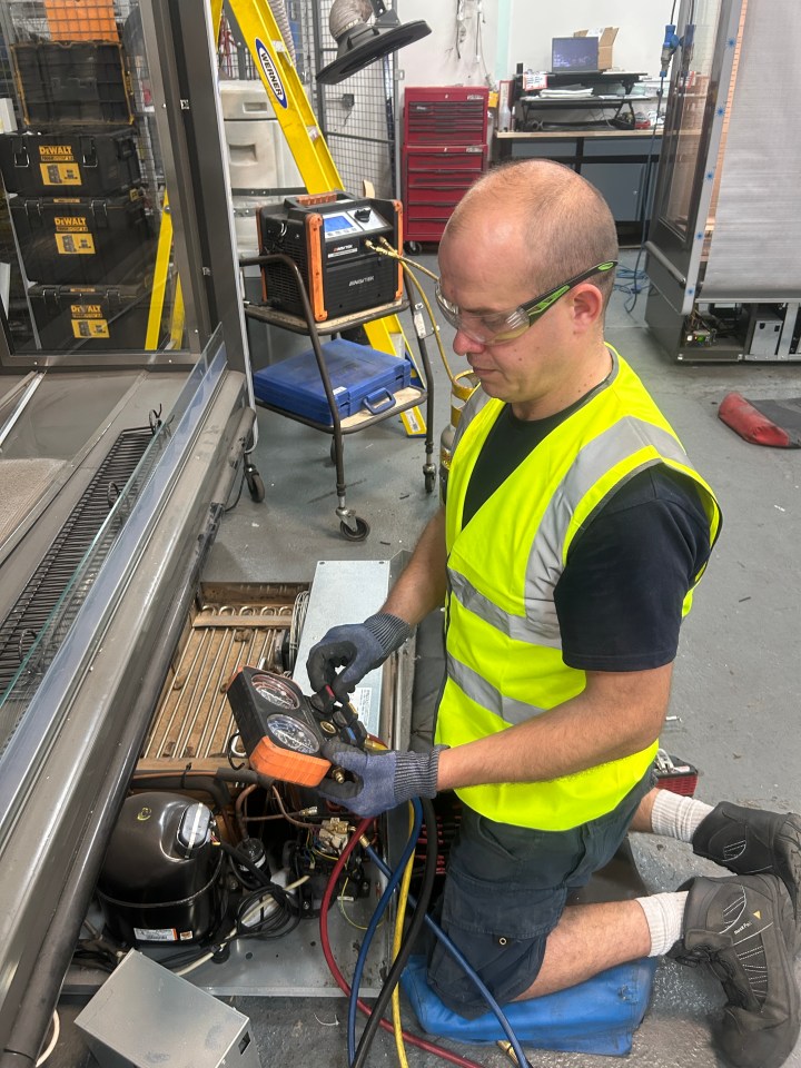Technician repairing refrigeration unit.