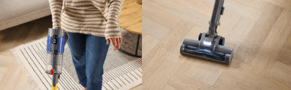 Person using a stick vacuum cleaner on hardwood floor.