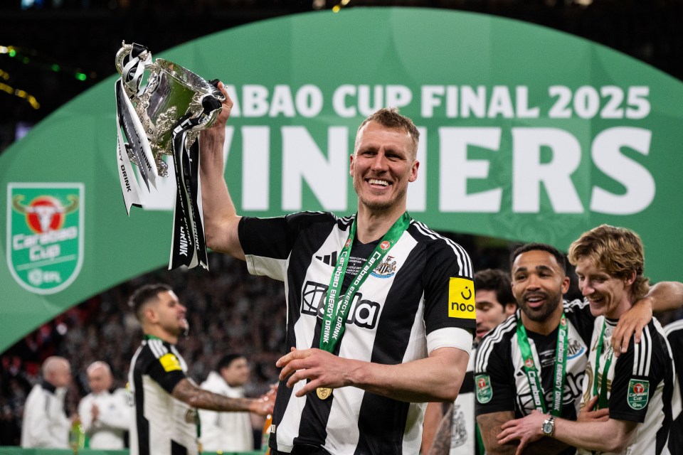 Dan Burn of Newcastle United holding the Carabao Cup trophy.