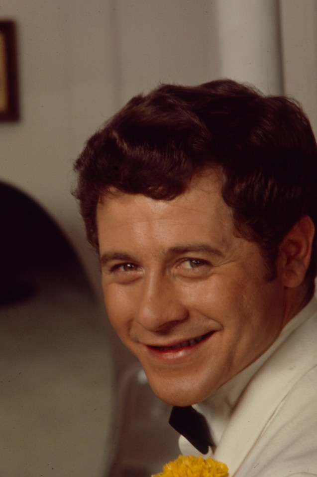 Alfie Wise in a white tuxedo, smiling.