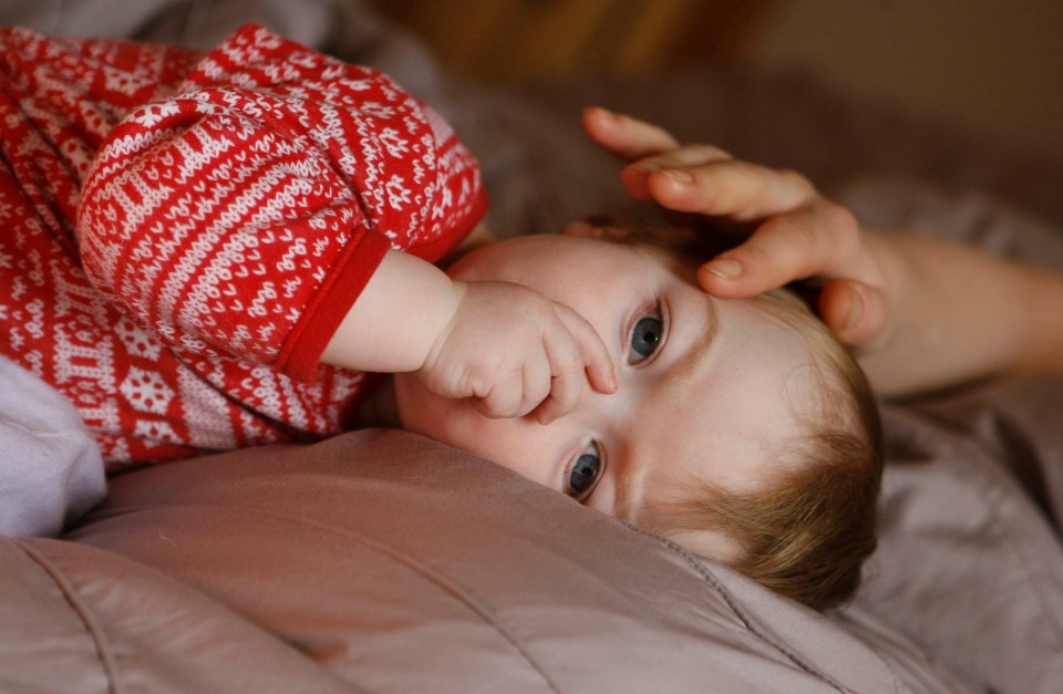 Baby lying on its back, sucking its thumb.