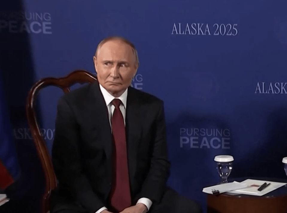 Vladimir Putin sitting at a table.