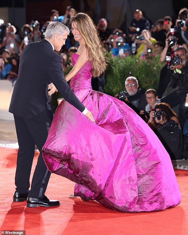 While Amal, 47 supported husband George, 64, at the Jay Kelly premiere at Venice Film Festival, Olivia, 51, walked the equally wet red carpet in London for her new movie The Roses