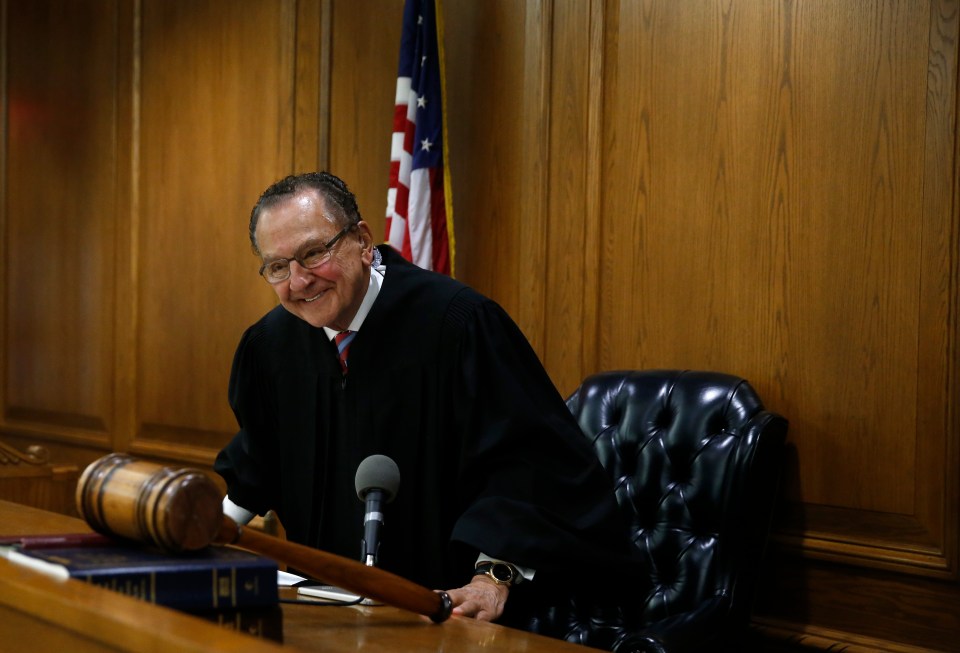 Judge Frank Caprio smiling in his courtroom.