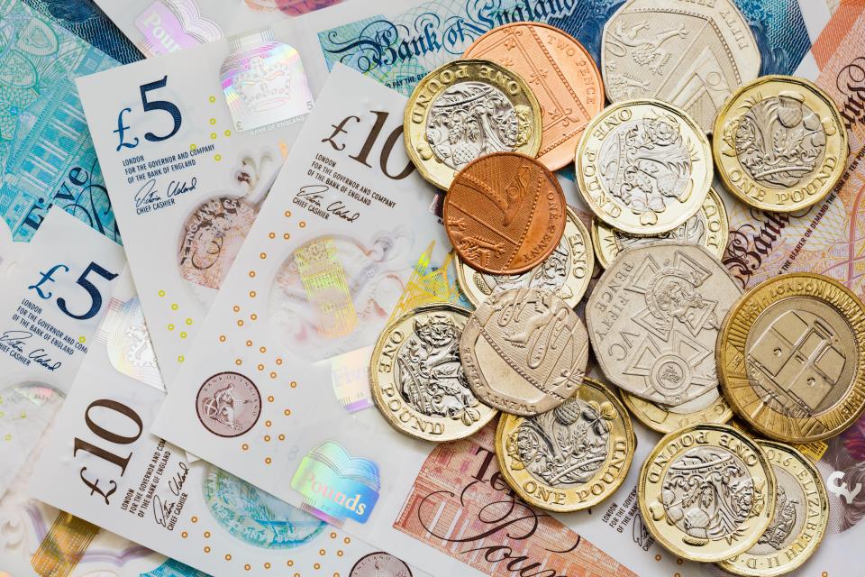 British £5 and £10 notes and various pound coins.