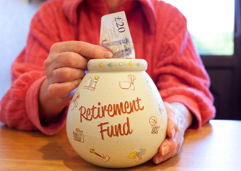 A person putting a twenty pound note into a retirement fund piggy bank.