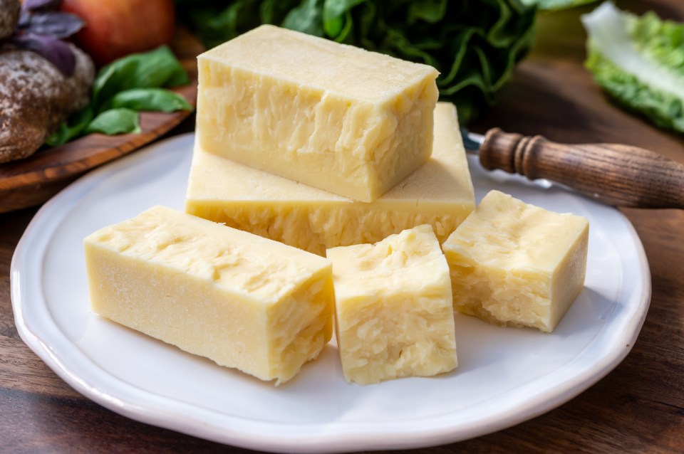 Pieces of aged British cheddar cheese on a plate.