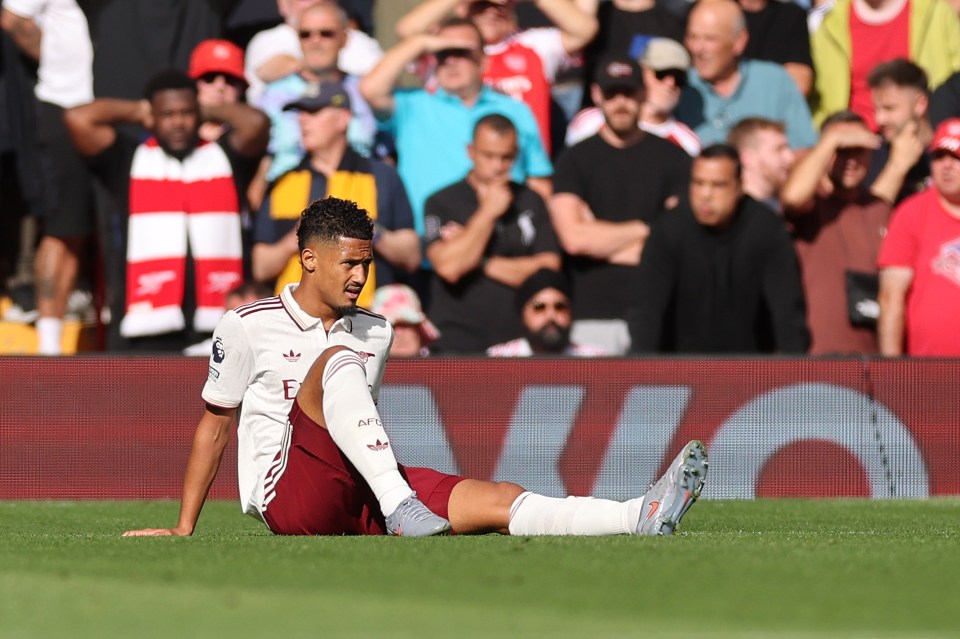 William Saliba of Arsenal reacting to an injury during a soccer match.