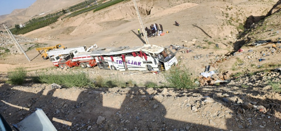 Bus crash scene with rescue workers.