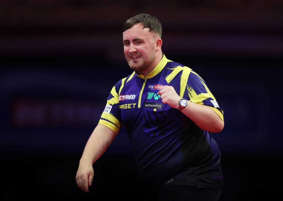 Luke Littler of England celebrates during a darts match.