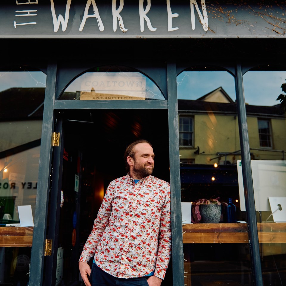 A man standing in the doorway of The Warren, a Coaltown speciality coffee shop.