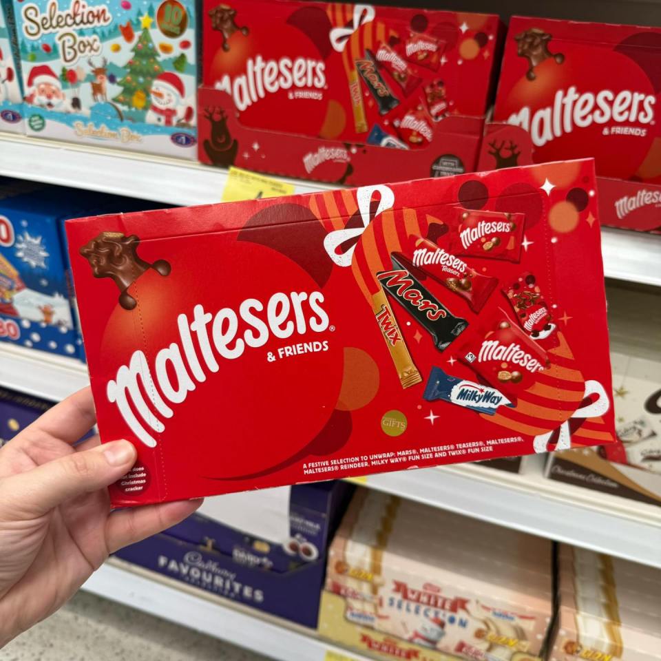 Hand holding a box of Maltesers & Friends festive chocolates.