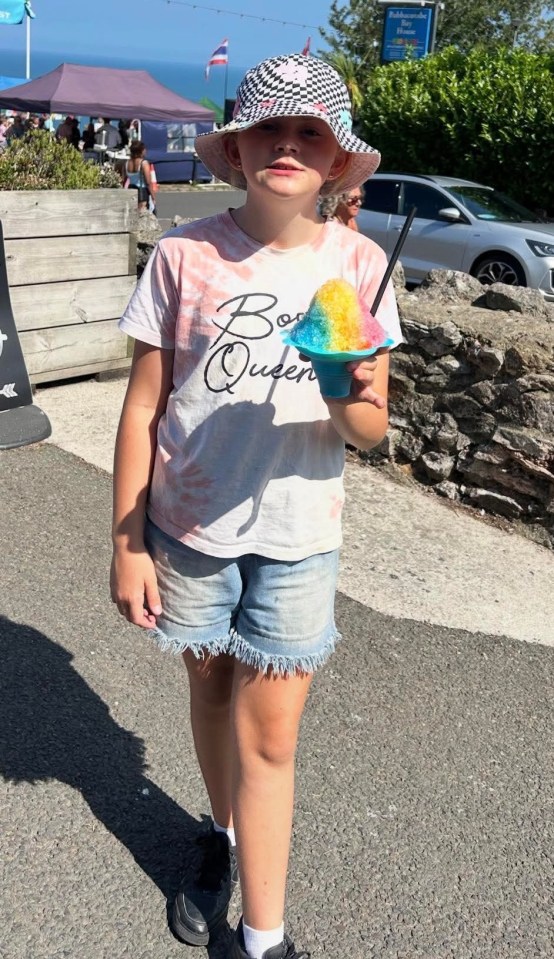 Girl holding a rainbow snow cone.