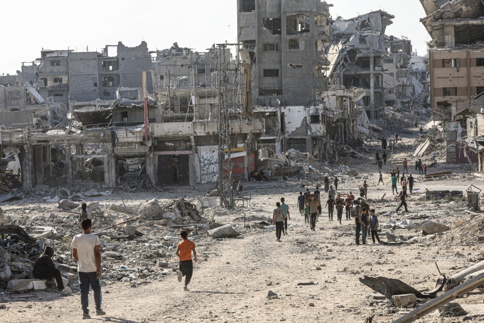 Destroyed buildings and people walking through rubble in Shujaiyya, Gaza.