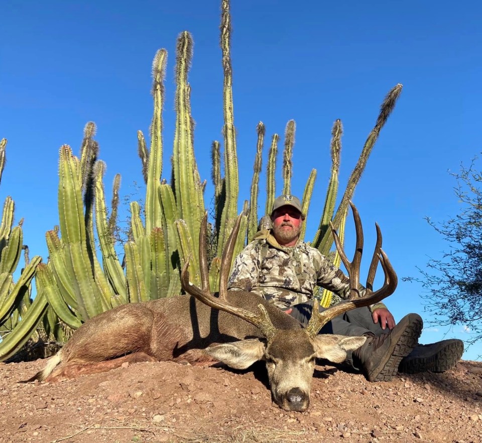 Hunter posing with a large desert mule deer.