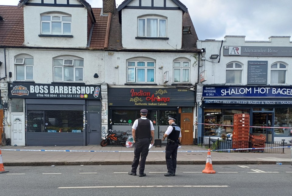 Police officers outside a restaurant in Ilford, East London, following a suspected arson attack.