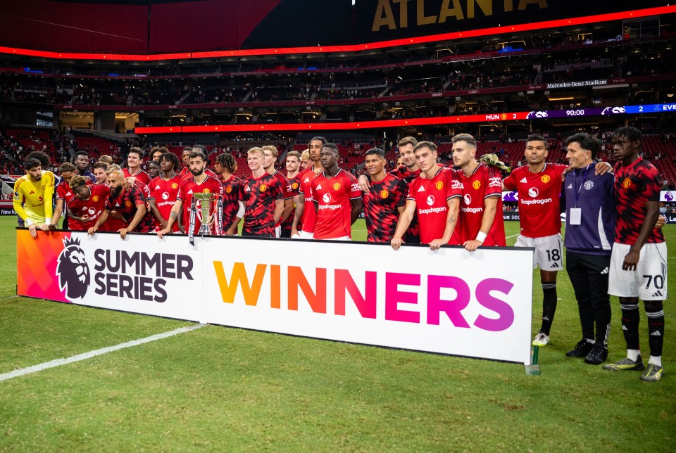 Manchester United players posing with the Premier League Summer Series trophy.