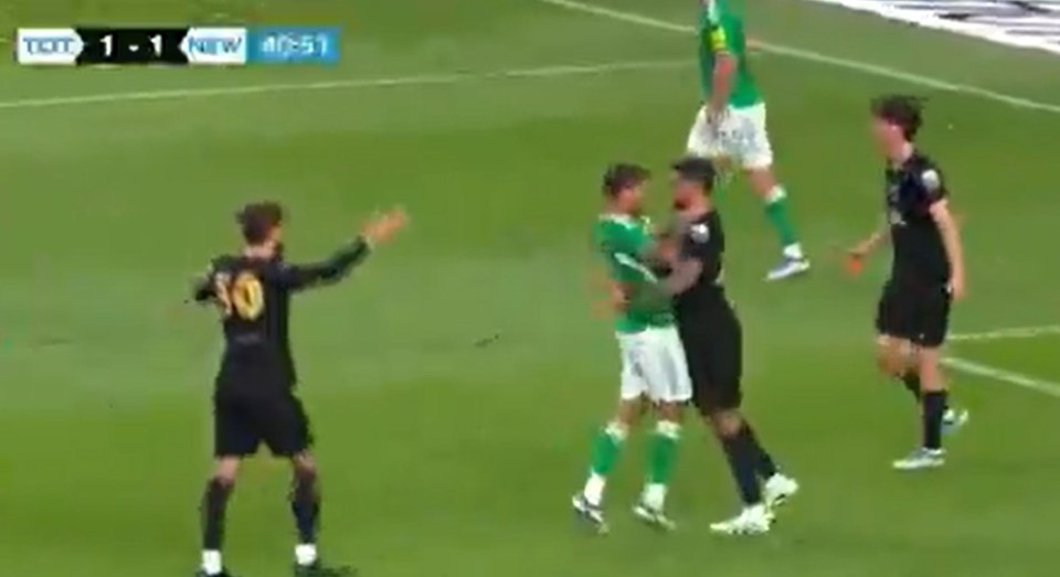 Soccer players arguing on the field.