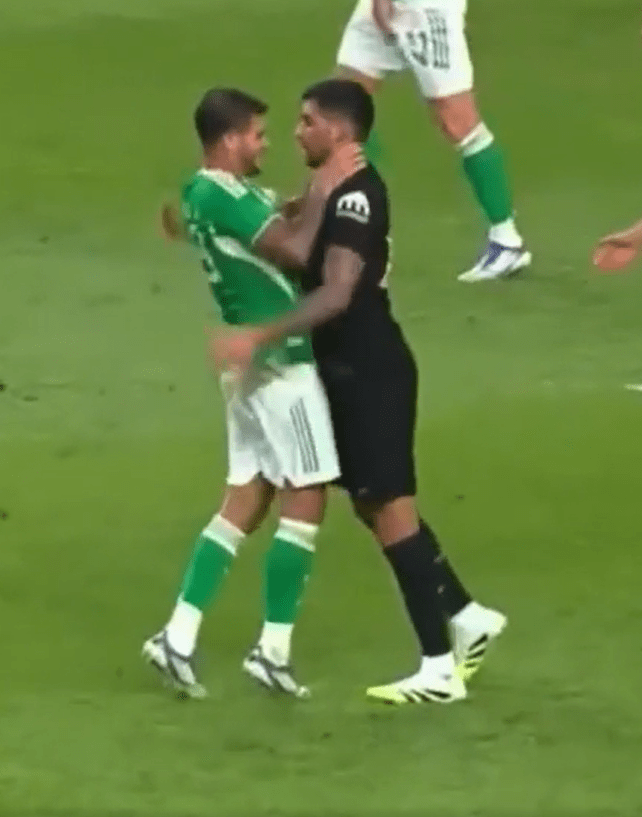 Two soccer players embracing on the field.