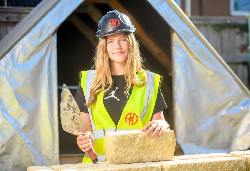Teenage girl starting bricklaying apprenticeship.