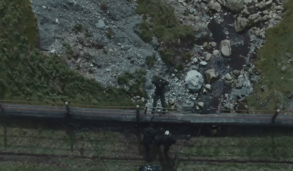 Aerial view of people working near a rocky stream.