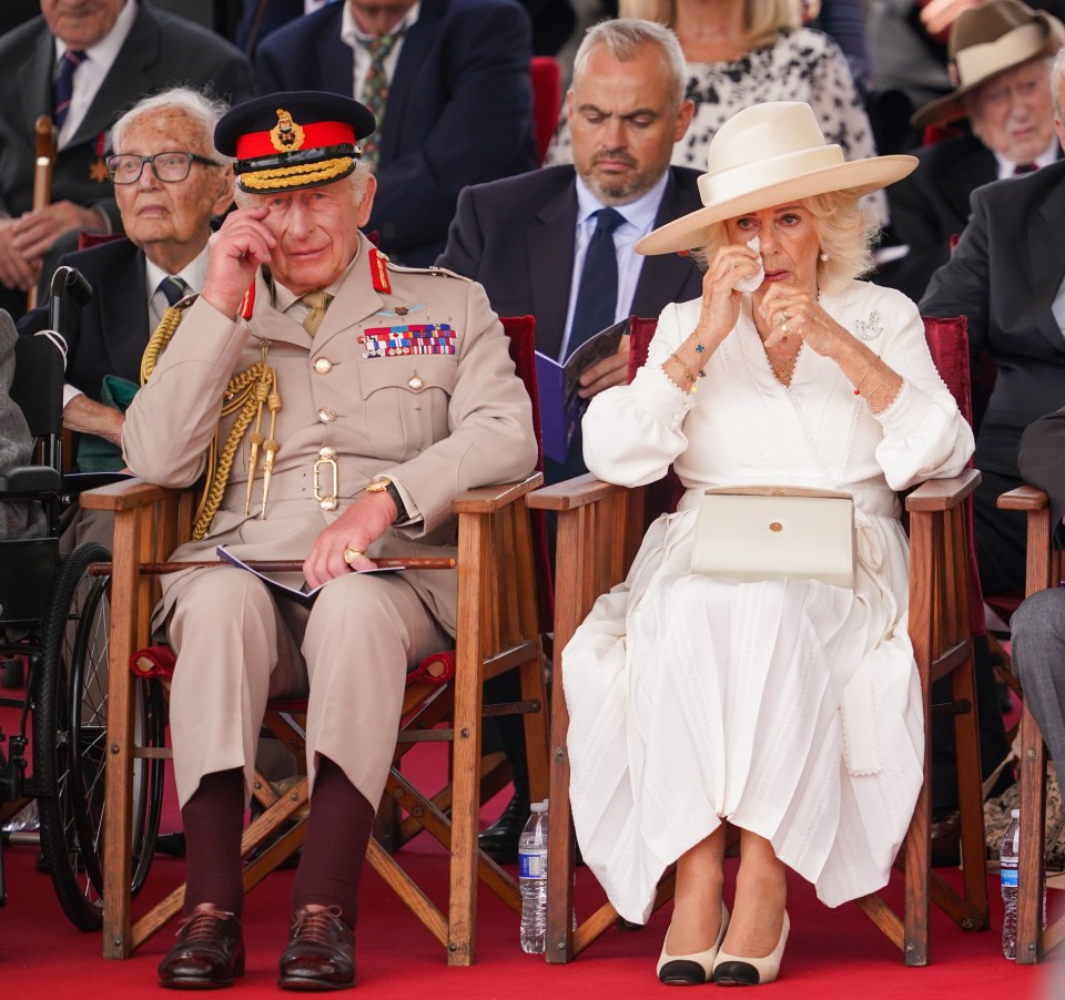 King Charles III and Queen Camilla wiping away tears at a VJ Day Remembrance service.