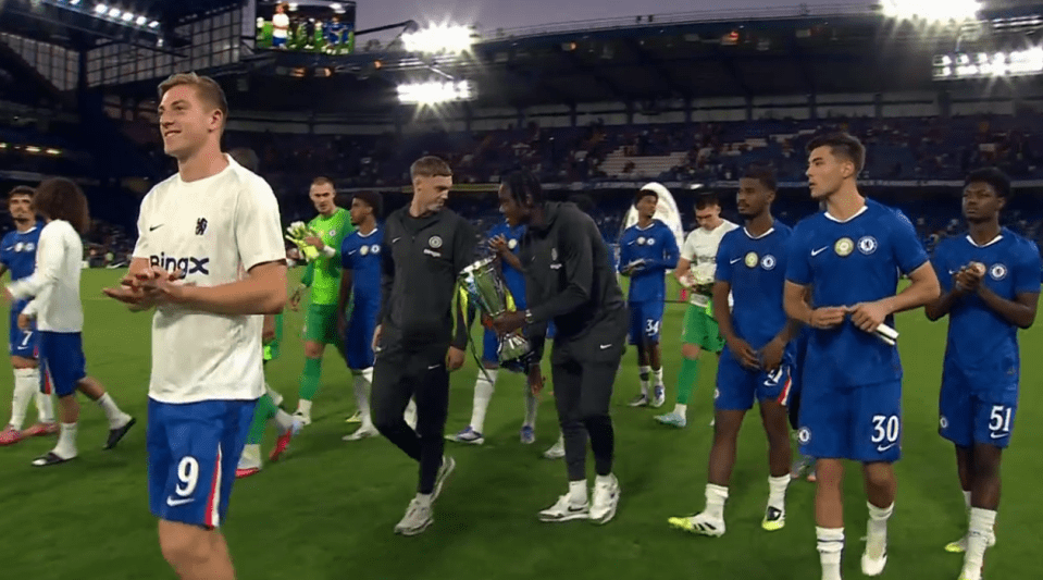 Chelsea football players with trophy.