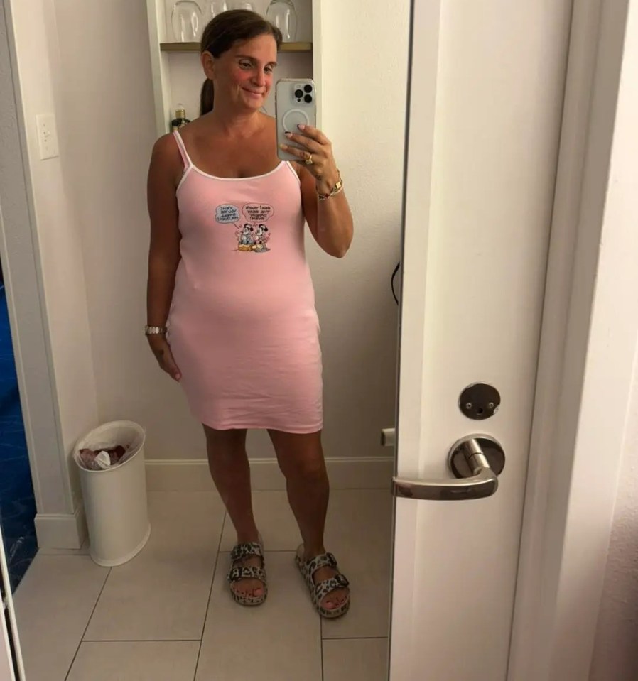 Woman in pink dress taking a selfie.