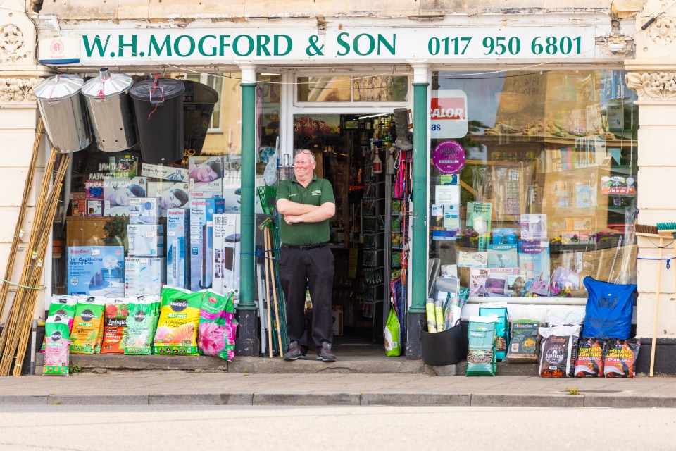 Paul Gillam, owner of a hardware store, standing in front of his shop.