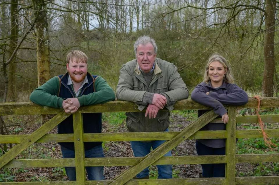Clarkson's Farm cast leaning on a gate.