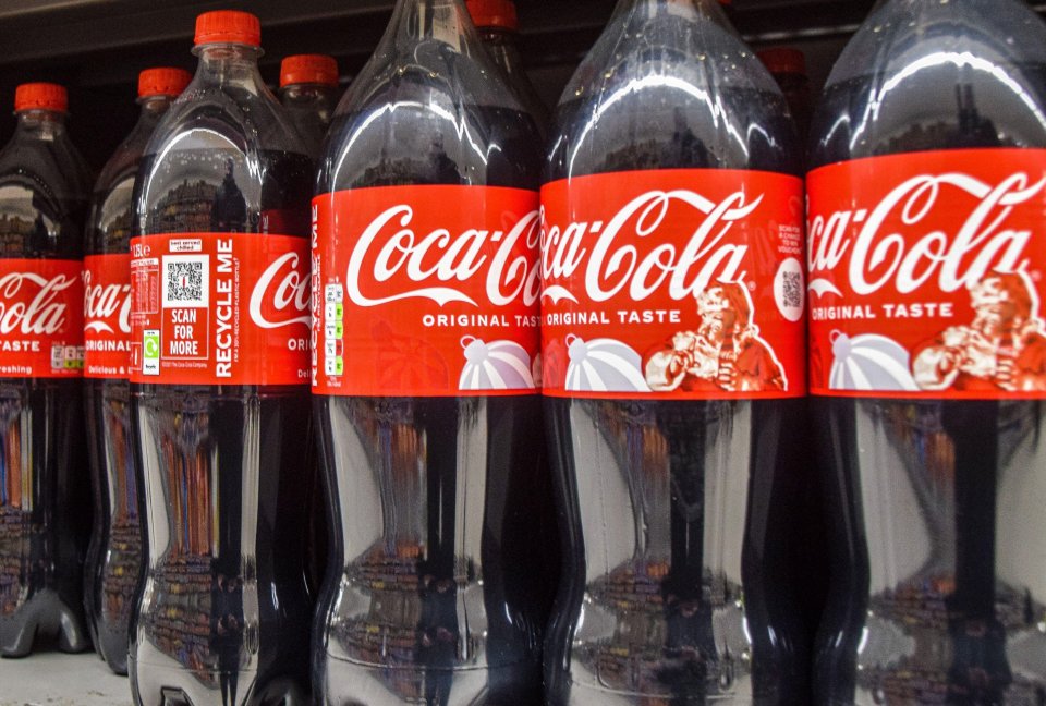 Coca-Cola bottles on a supermarket shelf.