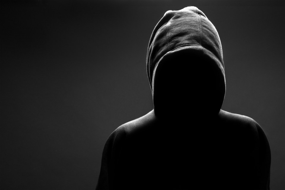 Silhouette of a person wearing a hooded sweatshirt.