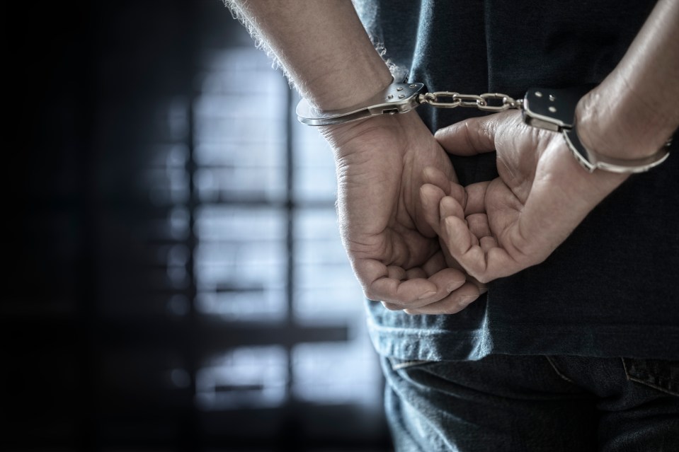 Man in handcuffs with hands behind his back.