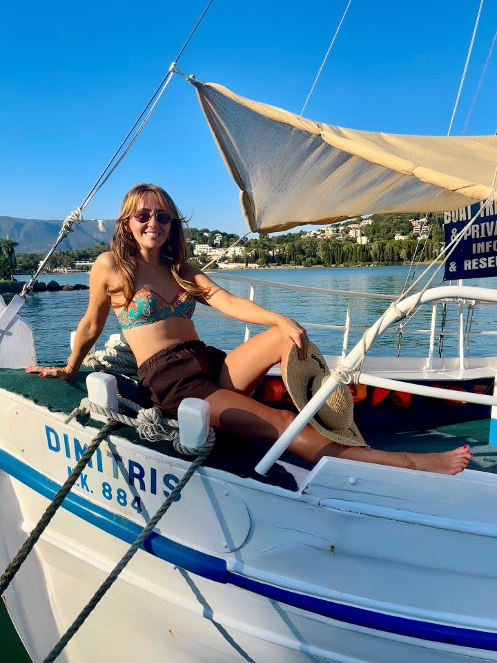 Woman in bikini sitting on a boat.