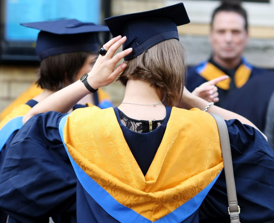 Graduates in caps and gowns at a university ceremony.