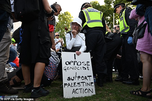Protesters sit with placards supporting Palestine Action in Parliament Square earlier this month