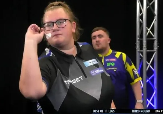 Beau Greaves throwing a dart during a darts match.