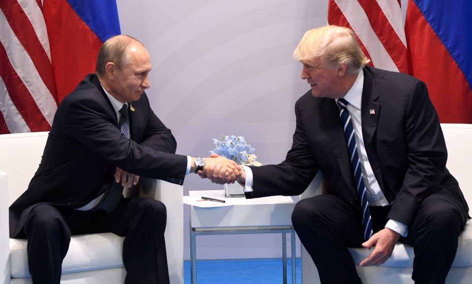 Presidents Trump and Putin shaking hands at a summit.